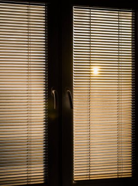 Dikey perdelerin arkasındaki güneş ışığı. 
