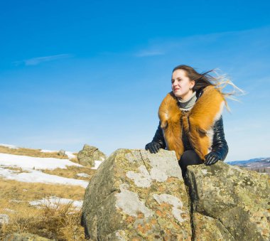 fox zencefil kürk yaka poz ile siyah montlu genç kadın. kış sezonu ve dağ manzara .