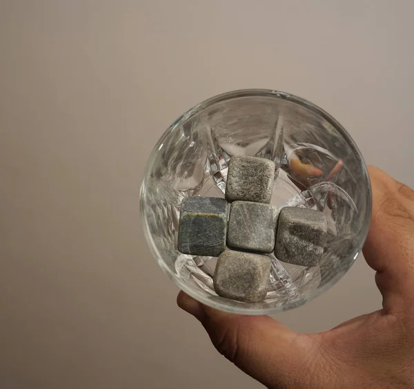 hand holding  empty glass with  stones