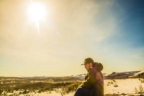 Jovem Sentado Sol Rodeado Por Montanhas Nevadas Olhando Para Baixo — Fotografia de Stock