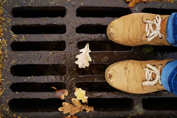 Tourist standing on drain cover — Stock Image Tourist standing on drain cover Stock Picture