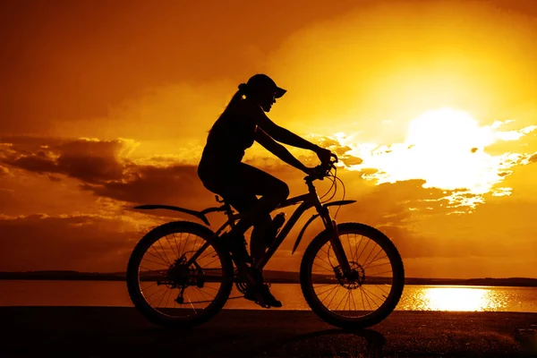 Σιλουέτα Του Νεαρή Γυναίκα Ποδηλάτη Στο Ηλιοβασίλεμα — Φωτογραφία Αρχείου