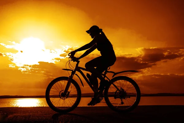 Σιλουέτα Του Νεαρή Γυναίκα Ποδηλάτη Στο Ηλιοβασίλεμα — Φωτογραφία Αρχείου