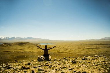 Rock zirvesine oturan adam.