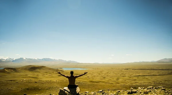 Man sitting  on the peak of rock.