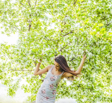 sıcak yaz güneşli bir günde elma ağacının yanında duran kadın 