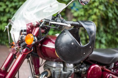 siyah kask asılı ile kırmızı bir retro vintage motosiklet yan görünüm.