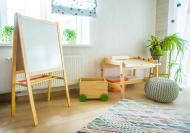 Taburesi ve resim masası olan anaokulu odası. Çocuk odası ve mobilya 