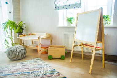 Taburesi ve resim masası olan anaokulu odası. Çocuk odası ve mobilya 