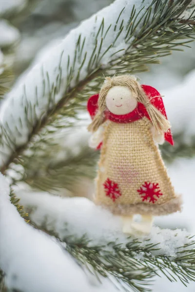 Christmas tree - Christmas angel on   snowy tree. Christmas card with an angel on a pine background. front view.