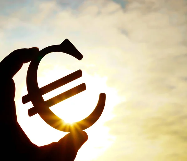 Ręka Mężczyzny Holding Euro Ikona Sylwetka Przeciw Słoneczne Niebo — Zdjęcie stockowe