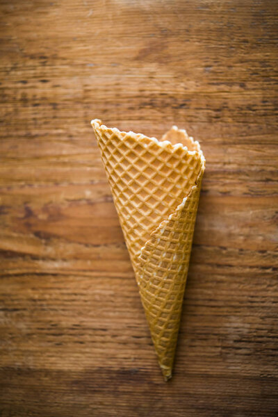 Empty wafer cone  on a wooden table background. sweet food background.