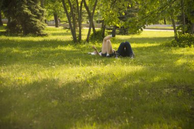 taze yeşil çim üzerinde yalan bir parkta genç bir çift. Bahar zaman sezon.