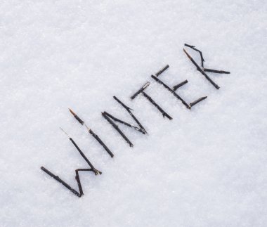 Kuru dalları veya beyaz kar arka plan üzerinde sopa kış kelime oluşan. 