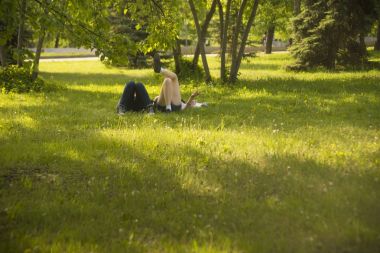 taze yeşil çim üzerinde yalan bir parkta genç bir çift. Bahar zaman sezon.