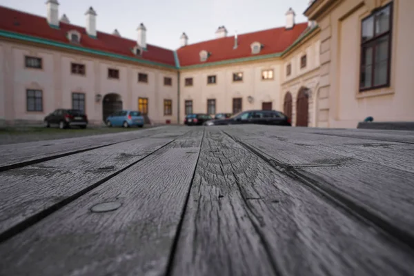 Empty wooden table with european house - building with parking cars on background. Wien, Austria.