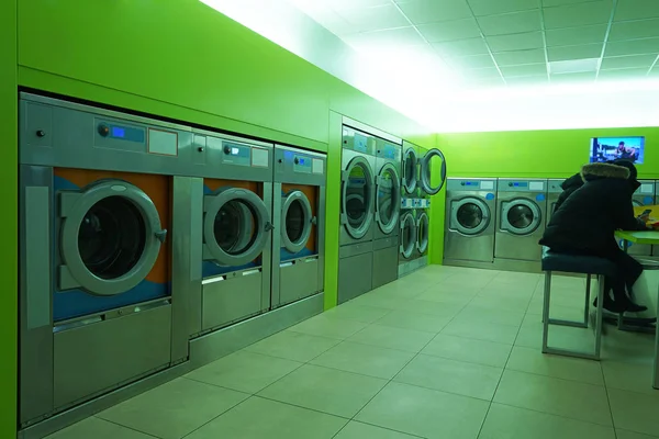 washing mashines stand in line. Row of industrial laundry machines