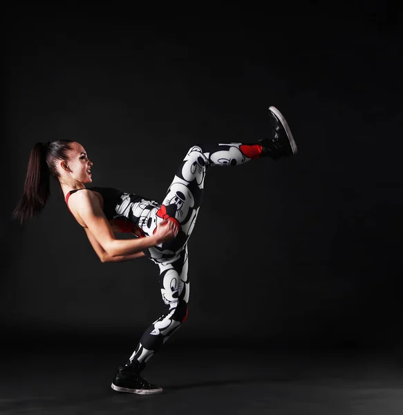 Portrait of young woman practicing  martial arts - high kick