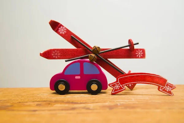 red wooden car with skis and ski poles isolated on white or gray background.