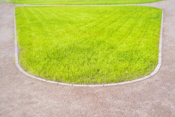 公園で石の経路 公園の緑の草の芝生とコンクリートの道 — ストック写真