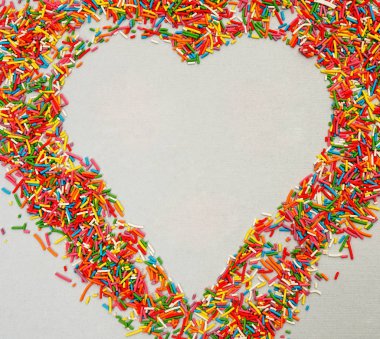 Renkli sprinkles şekilden kalp kapatmak kadar izole üzerinde beyaz arka plan