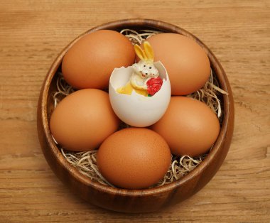Paskalya tablo. Ahşap plaka ve Paskalya tavşanı saman ile ahşap rustik tabloda kabuk içine üstten görünüm Paskalya yumurta
