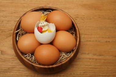 Paskalya tablo. Ahşap plaka ve Paskalya tavşanı saman ile ahşap rustik tabloda kabuk içine üstten görünüm Paskalya yumurta