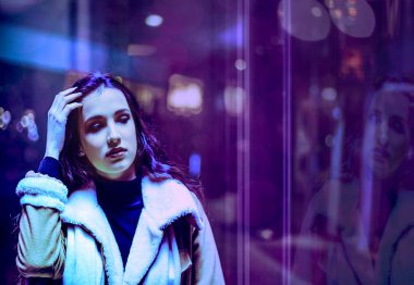 Gece şehir, şehir dramatik mor ve mor neon sokak arka plan aydınlatılmış gece boyunca poz güzel kadın