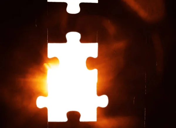 Last piece of the puzzle with light. Missing piece of puzzle. dark background