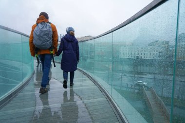 Fotoğraf yağmur şehirde yürüyüş iki genç insan. Su cam üzerine bırakır. Mevsim, modern kent kavramı. 