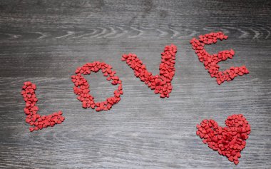 Kırmızı kalp birçok kırmızı Kalpler, bir kelime yapılan - siyah ahşap masa arka plan üzerinde seviyorum