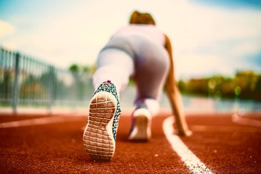 Arkadan Görünüm. Genç kız bir stadyum kırmızı yarış pisti 