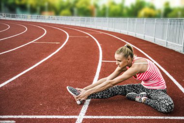 Runner kadın egzersiz önce - açık atış germe. Stadyum egzersiz yaparak spor kız.
