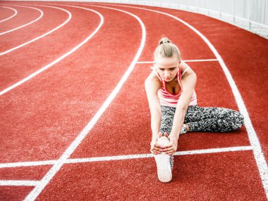 Runner kadın egzersiz önce - açık atış germe. Stadyum egzersiz yaparak spor kız.