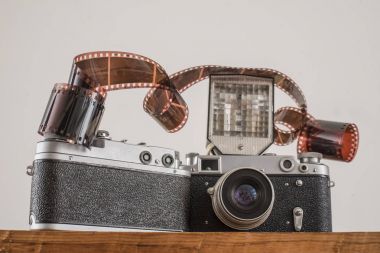 Eski fotoğraf film rulo, kaset ve beyaz arka plan üzerinde izole flash ile iki retro kamera.