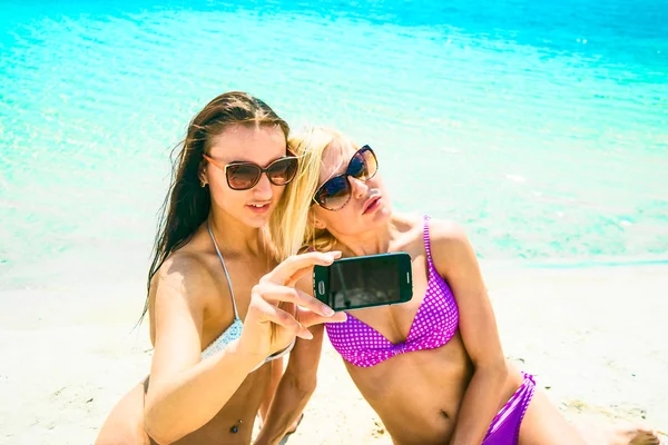 Dwa Uśmiechnięte Młode Kobiety Plaży Selfie Smartphone Ponad Niebieskie Wody — Zdjęcie stockowe