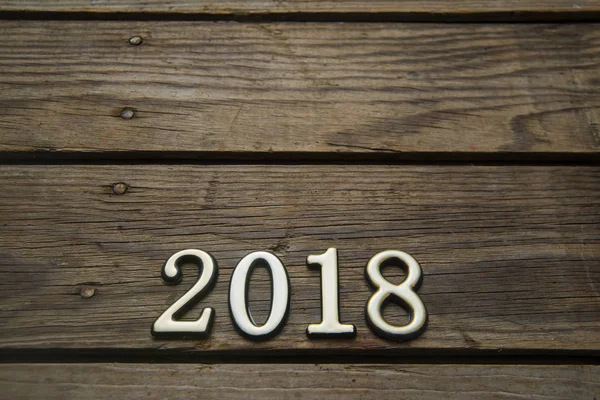 happy new Year 2018 card  - wooden number  on wooden plank background.