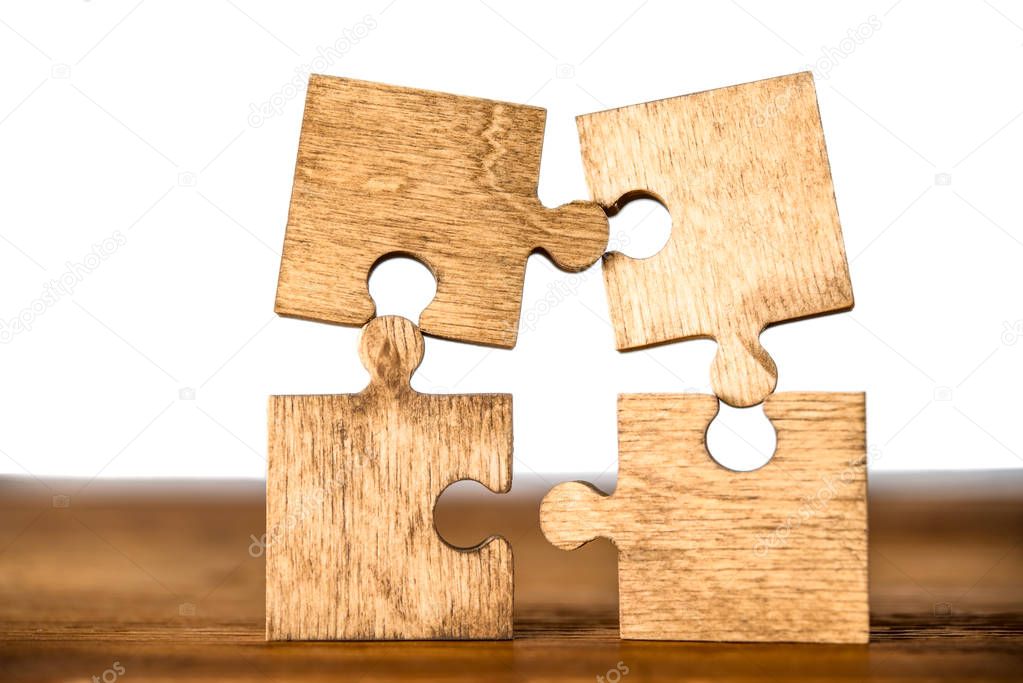 pieces of puzzle  on wooden table background. empty copy space for inscription or objects.