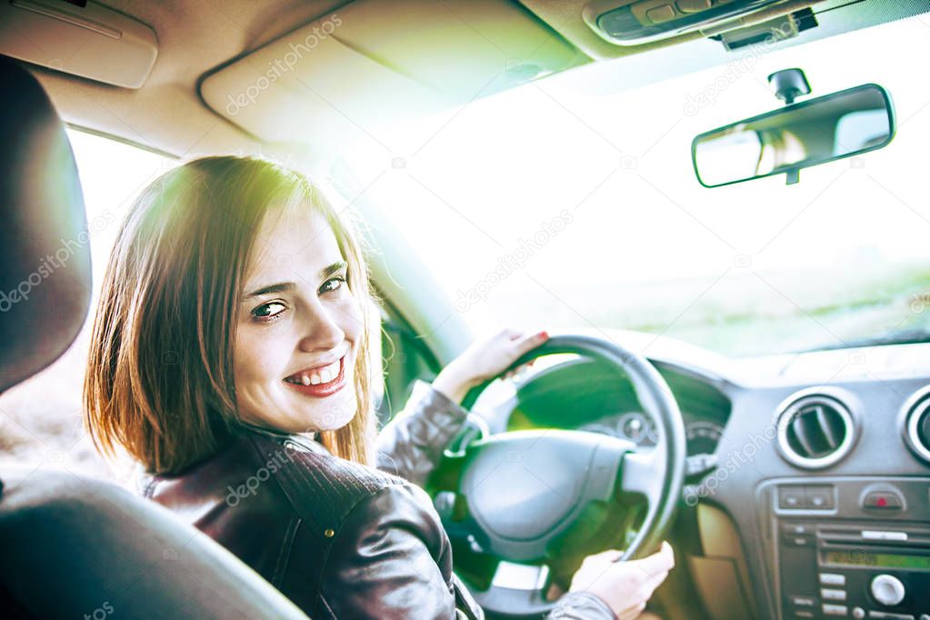 young woman in car  turning and   looking at passenger 