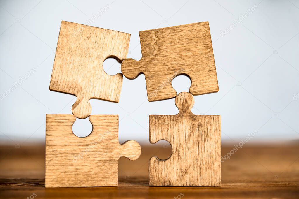 pieces of puzzle  on wooden table background. empty copy space for inscription or objects.