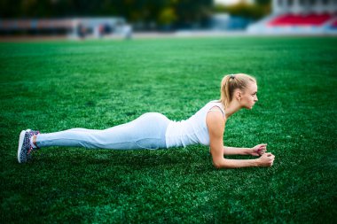 Stadyum tahta egzersiz yaparak ince atletik kadın 
