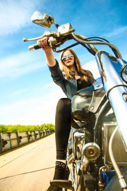 Helikopterdeki genç vahşi kız siyah deri elbise ve şık güneş gözlüğü takıyor. 