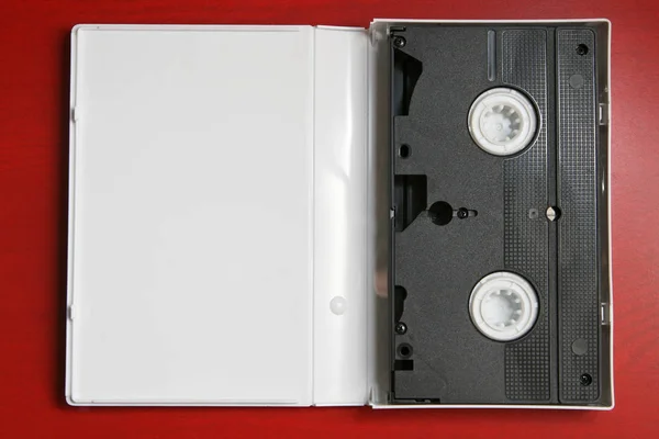 Raster Video Kaset Izole Kırmızı Zemin Üzerine Şeffaf Plastik Ambalaj — Stok fotoğraf