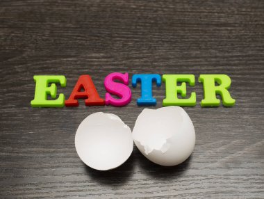 siyah arka plan ve kelime üzerinde kırık boş beyaz yumurta Paskalya renkli harfler yaptı.