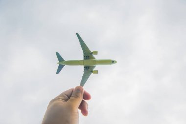 Model uçak güneşli gökyüzü bir arka plan üzerinde tutan eller. Güneş ışınları