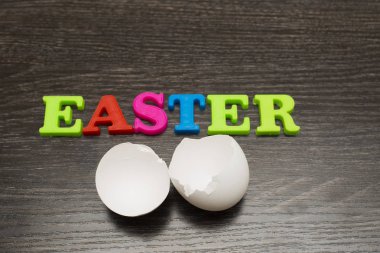 siyah arka plan ve kelime üzerinde kırık boş beyaz yumurta Paskalya renkli harfler yaptı.