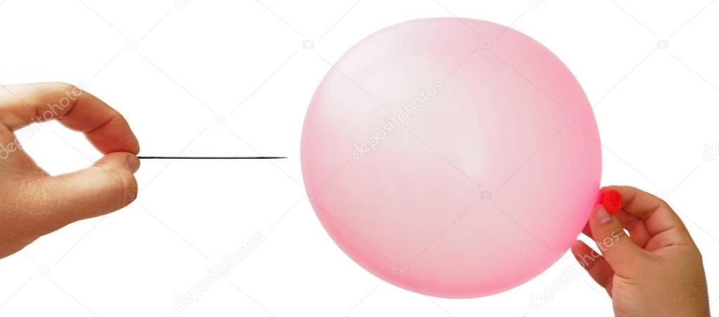 man's hand holding needle near pink balloon.  isolated on white background.