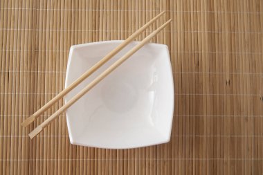 dikdörtgen kare beyaz boş plaka bir bambu masada yemek çubukları ile 
