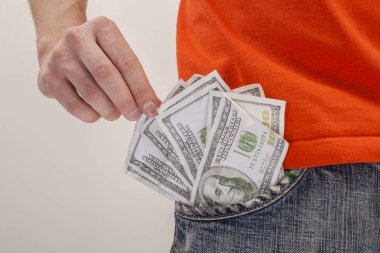 Erkek el kotunu, cebinden bir dolarlık banknot çekerek.