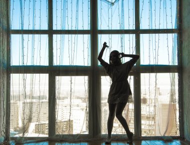 Müzik ve dans ve gülümseyen beyaz elbiseli güzel sarışın kız tam uzunlukta silüeti